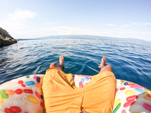 istock Man on floating doughnut in the sea 1258139056