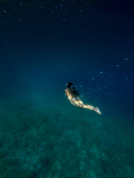 istock Woman swimming underwater 1258139064