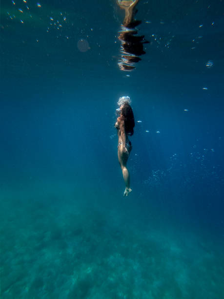 istock Woman swimming underwater 1258139074