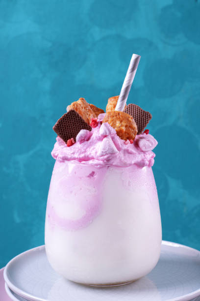 istock Milkshake topped with pink whipped cream and different cookies 1258139361