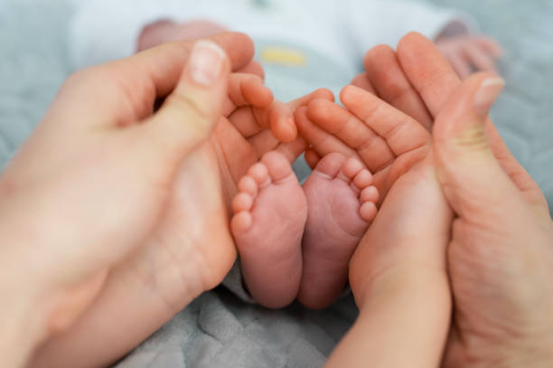 istock Selective focus shot of newborn baby's feet with hands around it 1258141538