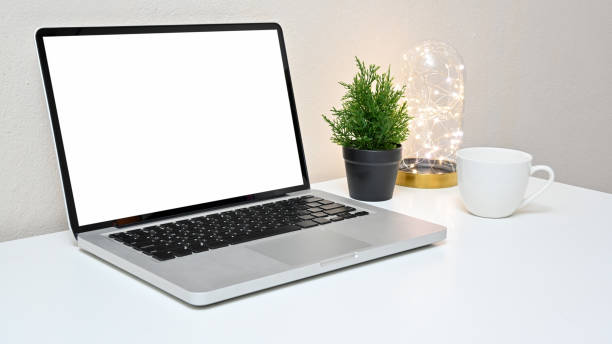 Stylish workspace with laptop, lightbulb, coffee cup and blank screen laptop on white table. Side view. concept work from home.