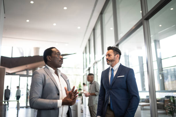 istock Two businessmen having a conversation in office lobby 1258144786