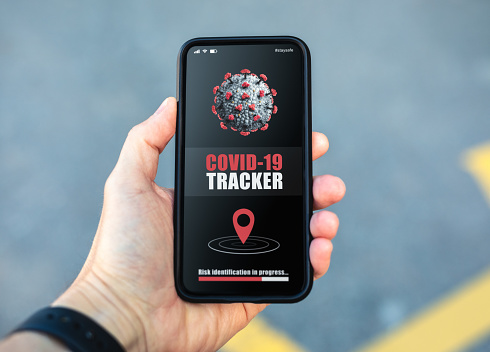 Man using a mobile phone with coronavirus tracing app installed on it.