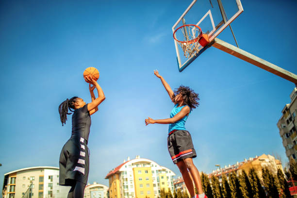 donna che gioca a basket nel parco giochi - jump shot foto e immagini stock
