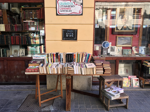 Valencia, Spain - July 10, 2020: Wooden table full of second hand books for sale. Usually book stores have this kind of offers besides the new books found inside