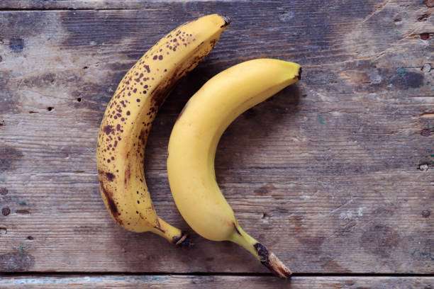 istock Two ripe bananas on wooden table 1258154327
