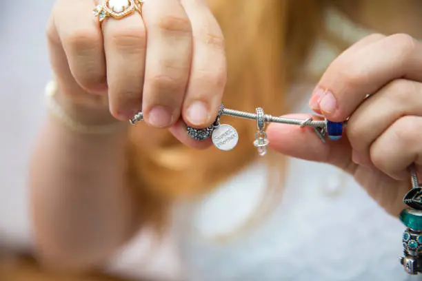 The mother is holding the child's bracelet. Sweet Mather is written on the bracelet.