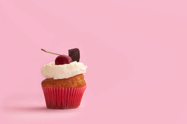 istock Tasty vanilla cupcake with cherry and chocolate topping. Festive background with copy space 1258156158