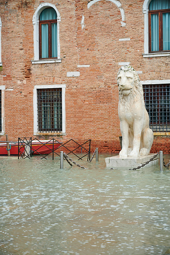 A lion statue at the entrance of Arsenale during high tide (Acqua Alta). Castello District. Venice. Italy.