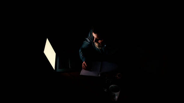 istock Businessman at laptop with light reflection 1258160719