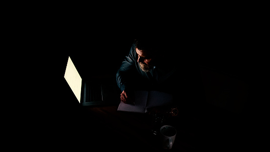 Businessman at laptop with light reflection