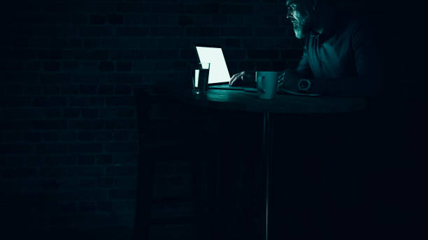 istock Businessman at laptop with light reflection 1258160751