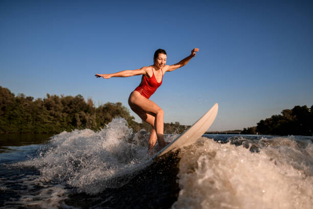 istock sports woman masterfully rides the wave on surfboard 1258160909