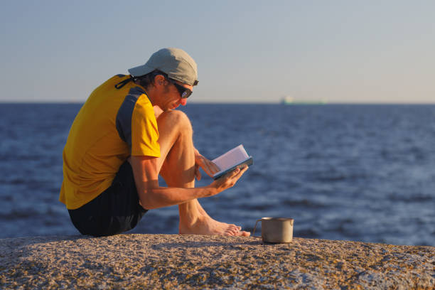 istock Man reading a book outdoors. 1258163664