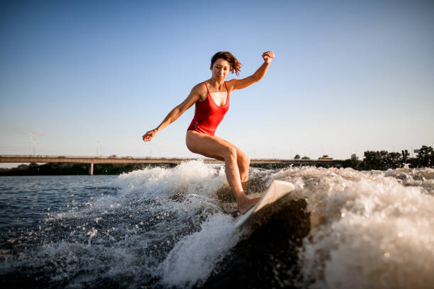 istock athletic woman masterfully rides the wave on surfboard 1258163910