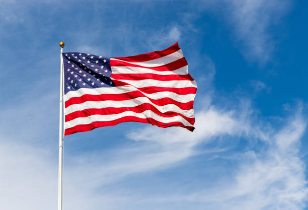 鮮豔的美國國旗在風中飄揚,鮮豔的紅白藍兩色被太陽照耀,與藍天對著複製空間。 - 美國國旗 個照片及圖片檔