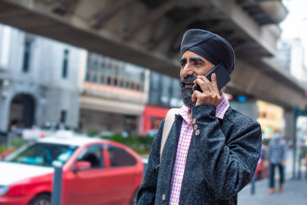 istock Sikh businessman using smart phone on street 1258165826