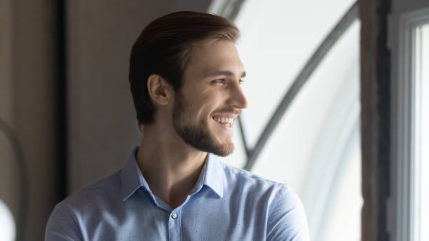 istock Smiling male employee look in distance planning or visualizing 1258168117