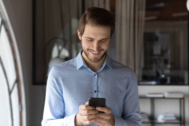 istock Smiling caucasian man using modern smartphone gadget 1258168137