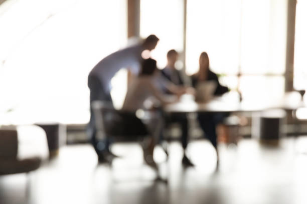 istock Blurry view of colleagues work together on project in office 1258168138