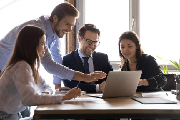 istock Smiling multiracial colleagues have fun working on laptop 1258168143