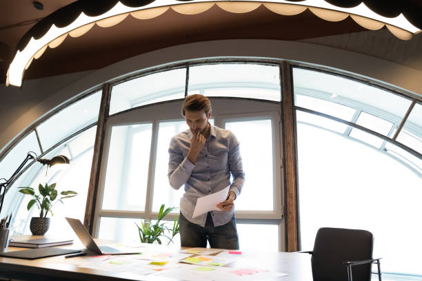 istock Pensive caucasian businessman analyze financial paperwork in office 1258168165