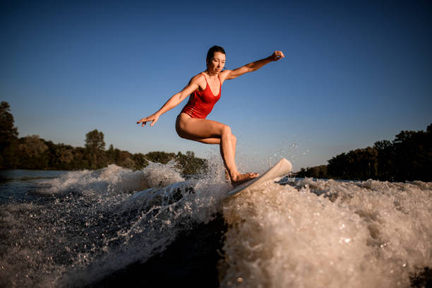 istock Active sports woman masterfully rides the wave on surfboard 1258170268
