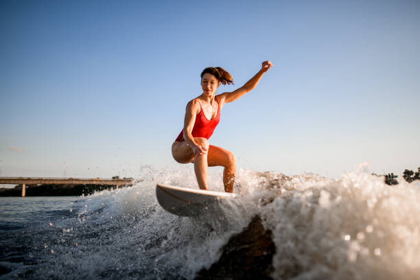 istock athletic woman rides the wave on surfboard 1258170339