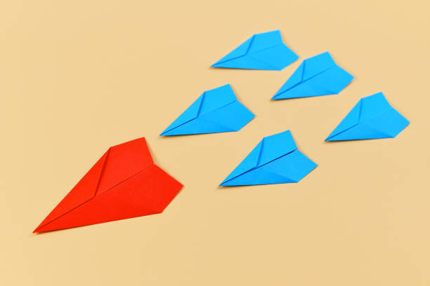 istock Red paper airplane leading blue airplanes 1258174887
