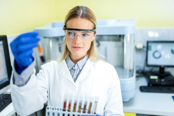 istock Young Female Scientist Looking at Blood Samples in Laboratory. 1258176207