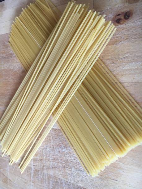 istock Making spaghetti meal dry spaghetti on wooden chopping board 1258177802