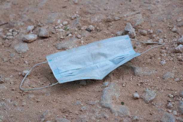 istock A dirty face mask is lying on a road. 1258183549