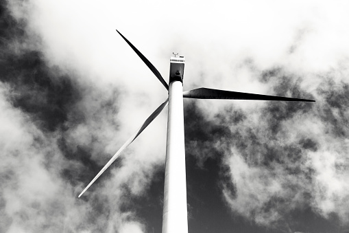 Black and white, top part of wind generator turbine, sky background with copy space, full frame horizontal composition