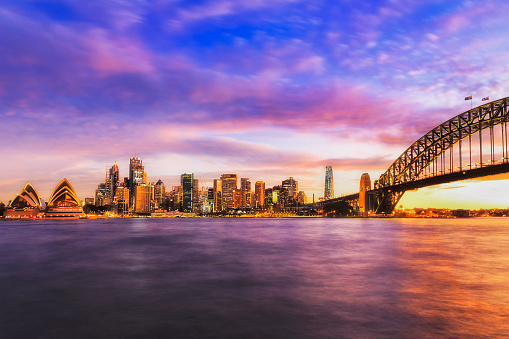 Colourful bright sunset in Sydney city around Harbour and CBD landmarks.