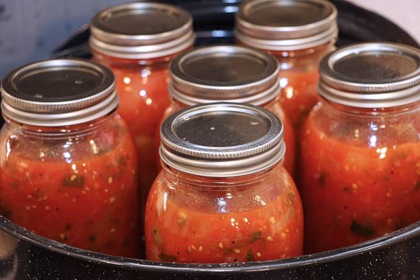 Homemade Canned Tomatoes Learning how to can your own vegetables is a healthy, cost effective old fashioned hobby. preserved food stock pictures, royalty-free photos & images