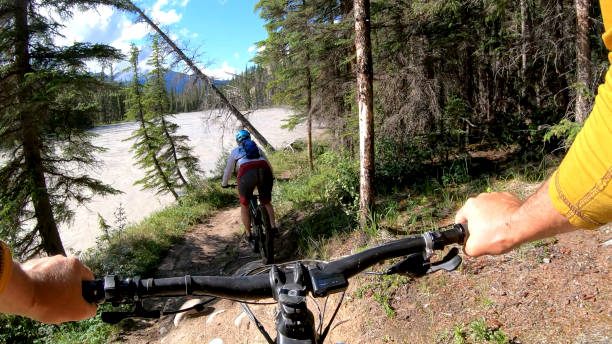 istock Mountain e-biking couple rides along forested path 1258263853