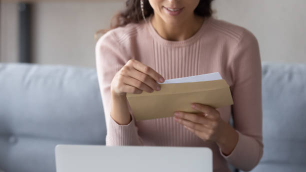 istock Close up of woman open envelope with postal letter 1258280044