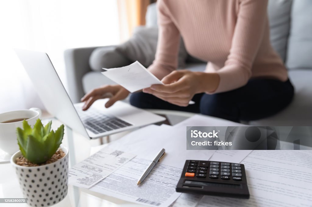 Close up of woman pay bills taxes on laptop Crop close up of economical woman work on laptop at home pay bills taxes on gadget online, provident female calculate finances expenditures on machine, manage plan family household budget on computer Financial Bill Stock Photo