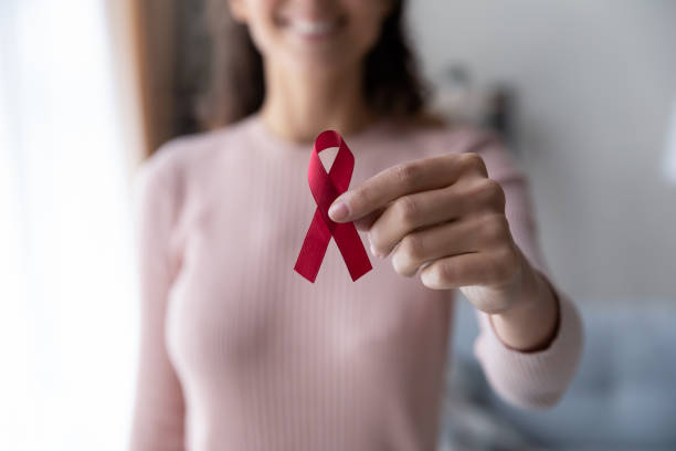 close-up de mulher segurar fita vermelha símbolo de câncer - cancer victim - fotografias e filmes do acervo