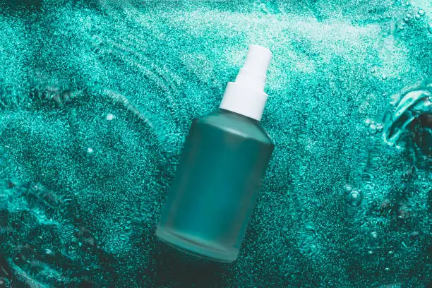 Photo of Transparent cosmetic bottle in water