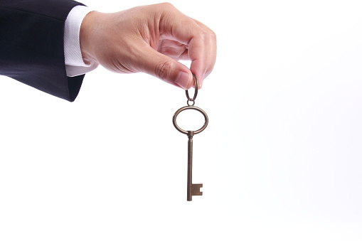 Business man hand holding success key, isolated on white background