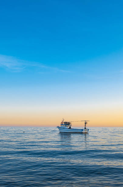 fishing boat and sunset on calm sea