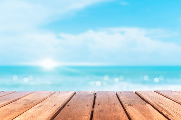 istock Selective focus of old wood table with blur beautiful beach background for display your product. 1258406684
