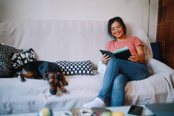 istock Girl reading a book on the sofa 1258416884