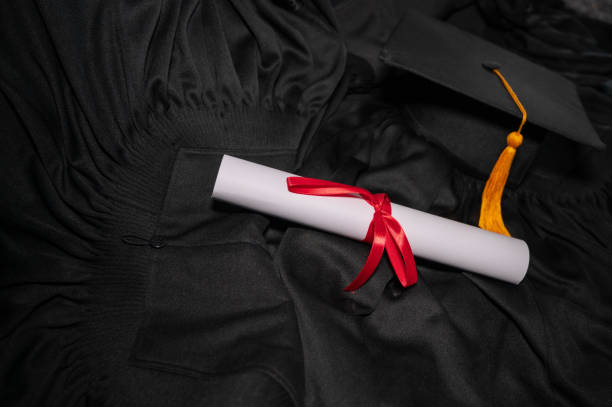 istock graduation cap placed on a black academic gown,Education concept 1258446847