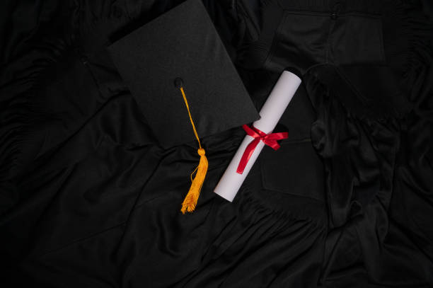 istock graduation cap placed on a black academic gown,Education concept 1258446859