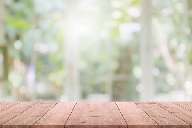 istock Empty wood table top and blurred of interior restaurant with window view green from tree garden background background - can used for display or montage your products. 1258462725