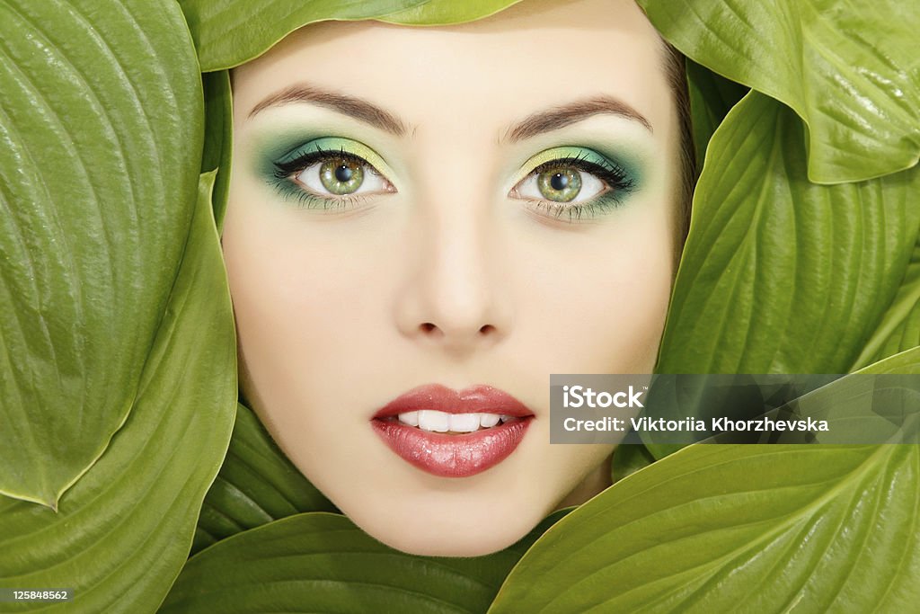 woman beauty face with green leaves frame  Adult Stock Photo