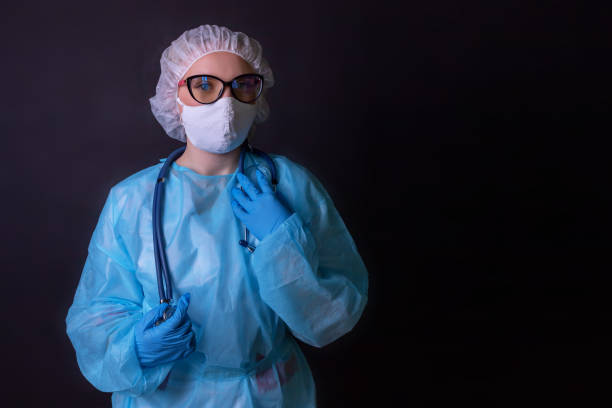 istock A nurse on a black background in a protective uniform 1258504926